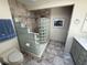 Bathroom featuring a tiled walk-in shower with glass block and neutral cabinets and fixtures at 25188 Marion Ave # 1, Punta Gorda, FL 33950