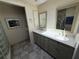Bathroom showcasing double sinks, updated cabinets, and a stylish glass block shower at 25188 Marion Ave # 1, Punta Gorda, FL 33950