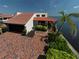 Waterfront home with a red tile roof offers an attached garage, mature landscaping, and a private outdoor patio at 25188 Marion Ave # 1, Punta Gorda, FL 33950