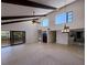 Open living room with beamed ceilings, tile floors, and sliding glass doors to the outdoor balcony at 25188 Marion Ave # 1, Punta Gorda, FL 33950