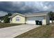 Side view of house featuring an attached garage, concrete driveway and easy access at 2696 Gisela Rd, North Port, FL 34287