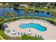 Aerial view of community pool, lounge area, pond, and residential houses at 2747 Suncoast Lakes Blvd, Punta Gorda, FL 33980