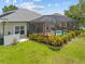 A screened-in lanai and landscaped backyard create an inviting atmosphere at 2747 Suncoast Lakes Blvd, Punta Gorda, FL 33980
