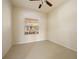 Bright bedroom featuring a ceiling fan and neutral tile flooring, offers a serene and comfortable living space at 2747 Suncoast Lakes Blvd, Punta Gorda, FL 33980