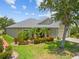 Charming single-story home with manicured landscaping, lush lawn and mature tree at 2747 Suncoast Lakes Blvd, Punta Gorda, FL 33980