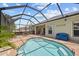A screened-in pool with brick pavers and a blue bench provides a relaxing outdoor space at 2747 Suncoast Lakes Blvd, Punta Gorda, FL 33980
