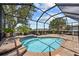 A screened-in pool with blue water and brick pavers overlooks a lush lawn and lake at 2747 Suncoast Lakes Blvd, Punta Gorda, FL 33980