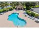Overhead view of community pool with surrounding lounge chairs, tables, and shade, near the lake at 2747 Suncoast Lakes Blvd, Punta Gorda, FL 33980