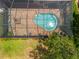 Aerial view of a screened-in pool with brick patio and lush landscaping at 2747 Suncoast Lakes Blvd, Punta Gorda, FL 33980