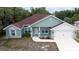 Charming single-Gathering home featuring a well-manicured lawn, a two-car garage, and a light teal exterior at 2858 Parlay Ln, North Port, FL 34286