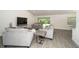 Comfortable living room showcasing stylish furniture, wood flooring, and sliding glass doors to bring the outside in at 2858 Parlay Ln, North Port, FL 34286