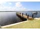 Wooden dock on the water featuring black posts and a beautiful view of the waterway on a sunny day at 3772 Peace River Dr, Punta Gorda, FL 33983