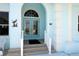 Elegant front entrance with an arched doorway, decorative glass doors, and stylish architectural details at 3772 Peace River Dr, Punta Gorda, FL 33983