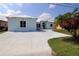 Charming home with a circular driveway, well-manicured lawn, and a vibrant blue exterior at 3772 Peace River Dr, Punta Gorda, FL 33983