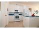 Well-lit kitchen with white appliances, cabinetry, and blue countertops at 3772 Peace River Dr, Punta Gorda, FL 33983
