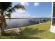 Backyard with palm tree featuring a dock and waterfront access on a sunny day at 3772 Peace River Dr, Punta Gorda, FL 33983