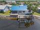 An aerial view of the canal-front home with a blue roof, deck, boat dock, and lush landscaping at 3825 Barnegat Dr, Punta Gorda, FL 33950