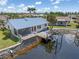 Waterfront home with a blue metal roof, screened lanai, and private boat lift at 3825 Barnegat Dr, Punta Gorda, FL 33950