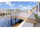 Waterfront home featuring a spacious deck with white railings, overlooking the canal and boat docks at 3825 Barnegat Dr, Punta Gorda, FL 33950