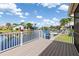 Waterfront home featuring a spacious deck with white railings, overlooking the canal and boat docks at 3825 Barnegat Dr, Punta Gorda, FL 33950