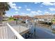 Waterfront home featuring a spacious deck with white railings, overlooking the canal and boat docks at 3825 Barnegat Dr, Punta Gorda, FL 33950