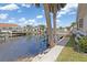 Waterfront home featuring a spacious deck with white railings, overlooking the canal and boat docks at 3825 Barnegat Dr, Punta Gorda, FL 33950