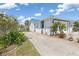 Beautiful home exterior with a well-maintained driveway, blue accents, and mature tropical landscaping at 3825 Barnegat Dr, Punta Gorda, FL 33950