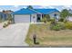 Single-story home featuring a bright blue metal roof, a white garage door and decorative landscaping at 3825 Barnegat Dr, Punta Gorda, FL 33950