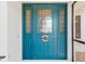 Vibrant turquoise front door with decorative sidelights and transom window, adorned with a nautical 'Welcome Aboard' wreath at 3825 Barnegat Dr, Punta Gorda, FL 33950