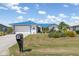 Inviting home exterior with lush green lawn, mature landscaping, and a vibrant blue metal roof at 3825 Barnegat Dr, Punta Gorda, FL 33950