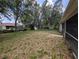 Lush backyard with mature trees and a view of the home, offering a serene outdoor space at 4205 Simkins Ave, North Port, FL 34286