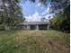 Spacious backyard featuring a screened-in porch, providing a comfortable outdoor living space, and lush greenery at 4205 Simkins Ave, North Port, FL 34286