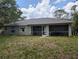 A covered, screened-in patio is perfect for relaxing while overlooking this home's expansive, lush backyard at 4205 Simkins Ave, North Port, FL 34286