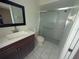 This renovated bathroom features a vanity with marble top, a shower with glass door, and modern fixtures at 4205 Simkins Ave, North Port, FL 34286
