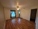 This bedroom offers laminate floors, a ceiling fan, and a window with decorative curtains at 4205 Simkins Ave, North Port, FL 34286