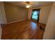 Cozy bedroom showcases hardwood floors, ceiling fan, and a window with decorative curtains at 4205 Simkins Ave, North Port, FL 34286