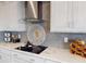 Close-up of modern kitchen featuring a sleek cooktop, stylish backsplash, and ample cabinet space at 4426 Vasco St, Punta Gorda, FL 33950