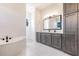 Bright bathroom featuring double vanity, soaking tub, and walk-in shower with marble tiling at 5061 Collingswood Blvd, Port Charlotte, FL 33948