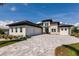 Stunning modern home featuring a paver driveway, attached garage, and well-manicured landscaping at 5061 Collingswood Blvd, Port Charlotte, FL 33948