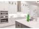Bright kitchen with double ovens, custom fixtures, stainless appliances, and designer tile backsplash at 5061 Collingswood Blvd, Port Charlotte, FL 33948