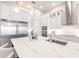 Beautiful kitchen featuring a large waterfall island, custom fixtures, stainless appliances, and designer tile backsplash at 5061 Collingswood Blvd, Port Charlotte, FL 33948