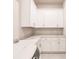 Bright laundry room featuring white cabinets, marble countertops, and stainless-steel faucet at 5061 Collingswood Blvd, Port Charlotte, FL 33948