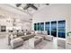 Spacious living room with a modern sectional sofa, views to outdoor pool, and gourmet kitchen in a modernly designed home at 5061 Collingswood Blvd, Port Charlotte, FL 33948