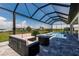 Entertain with ease in this screened in pool, hot tub, and patio with water views in the distance at 5061 Collingswood Blvd, Port Charlotte, FL 33948