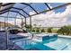 Beautiful backyard features a screened-in pool, hot tub and patio with lush landscaping and serene lake views at 5061 Collingswood Blvd, Port Charlotte, FL 33948