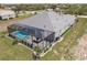 Beautiful aerial view of the house with a screened-in pool, hot tub and outdoor seating, all surrounded by manicured landscaping at 5061 Collingswood Blvd, Port Charlotte, FL 33948