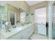Bathroom with a double sink vanity, cabinet, and glass block shower at 5219 Guava Ter, Port Charlotte, FL 33981