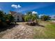 Landscaped front yard with palm trees and lush greenery enhances the curb appeal of this charming home at 5219 Guava Ter, Port Charlotte, FL 33981