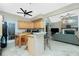 Open kitchen features wood cabinets, modern appliances, and flows into the adjacent living room with a fireplace at 5219 Guava Ter, Port Charlotte, FL 33981