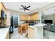 Bright kitchen with wood cabinets, black appliances, and island, creating a functional and stylish cooking space at 5219 Guava Ter, Port Charlotte, FL 33981